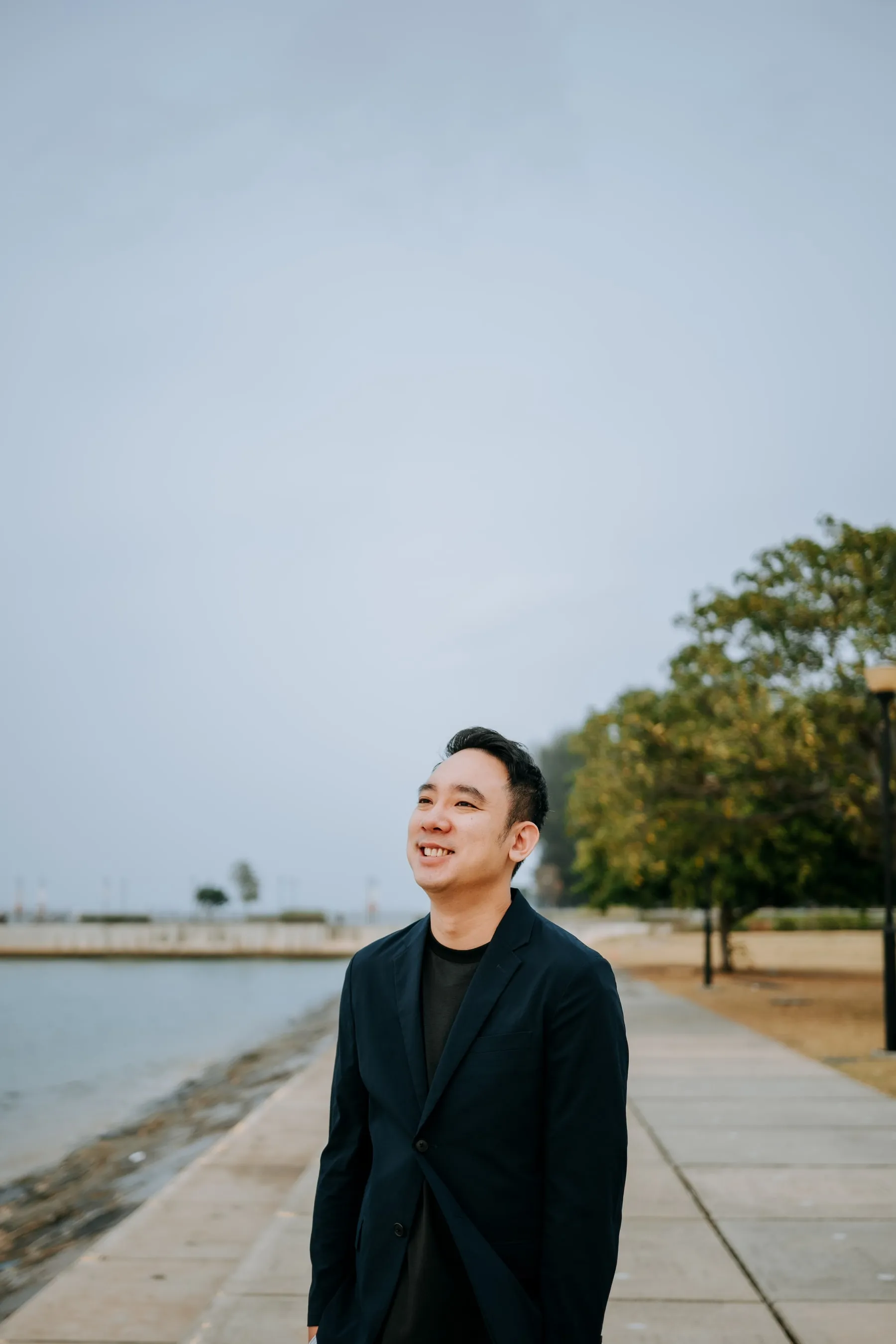 Aloysius smiling beside the waterfront in Singapore