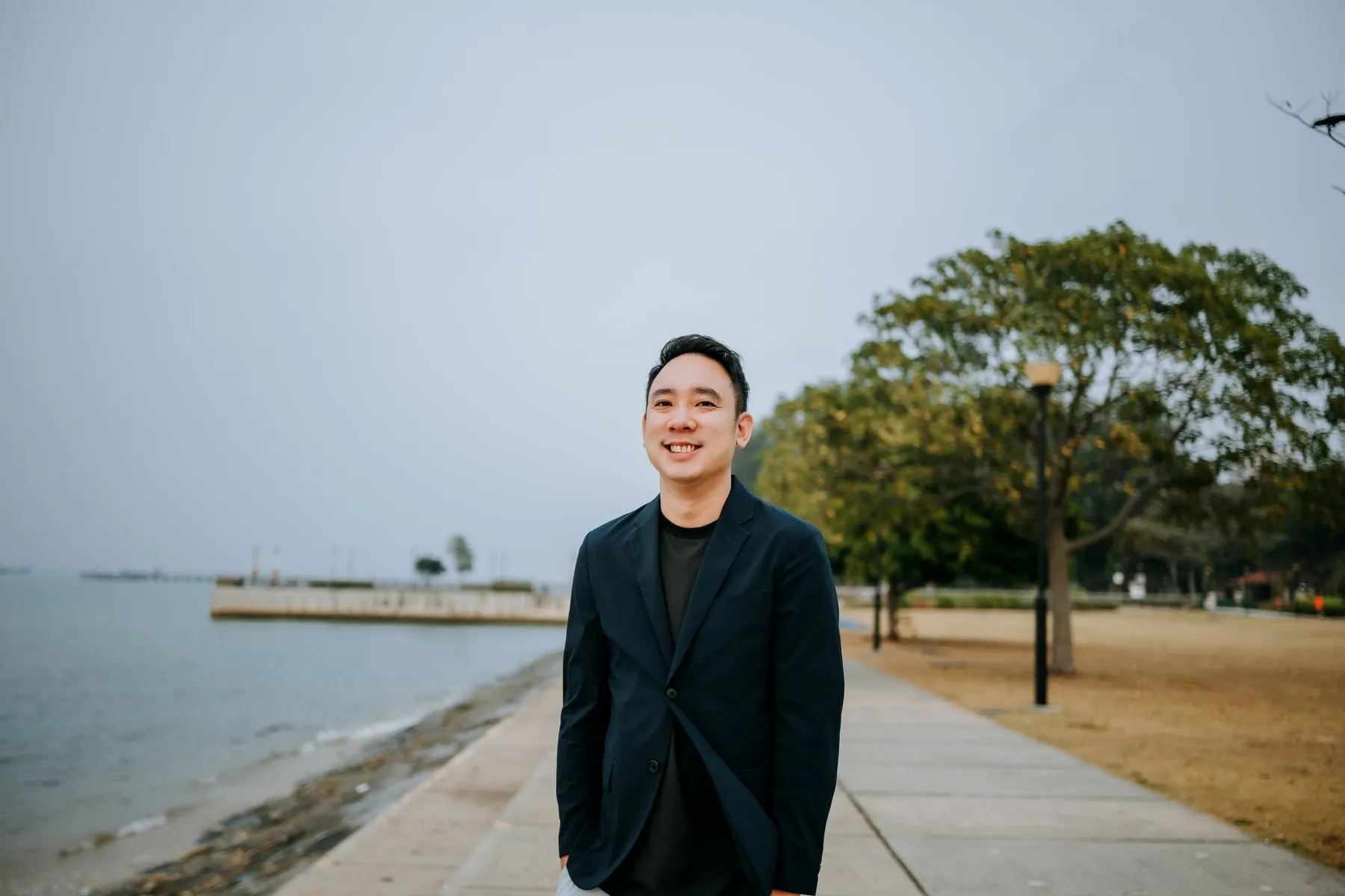 Aloysius standing beside the waterfront in Singapore