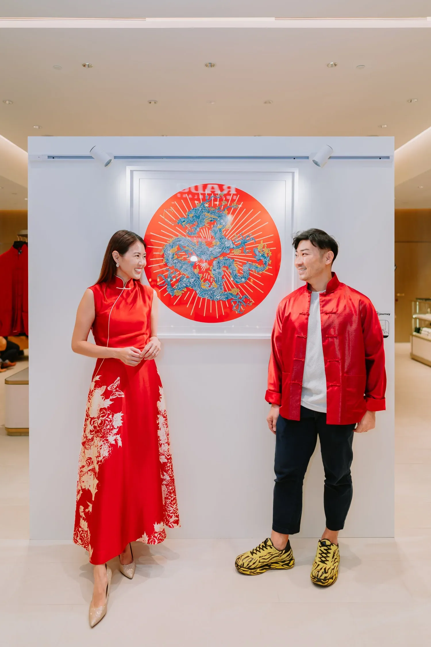 Two people sharing a smile beside a colourful artwork at a Shanghai Tang event